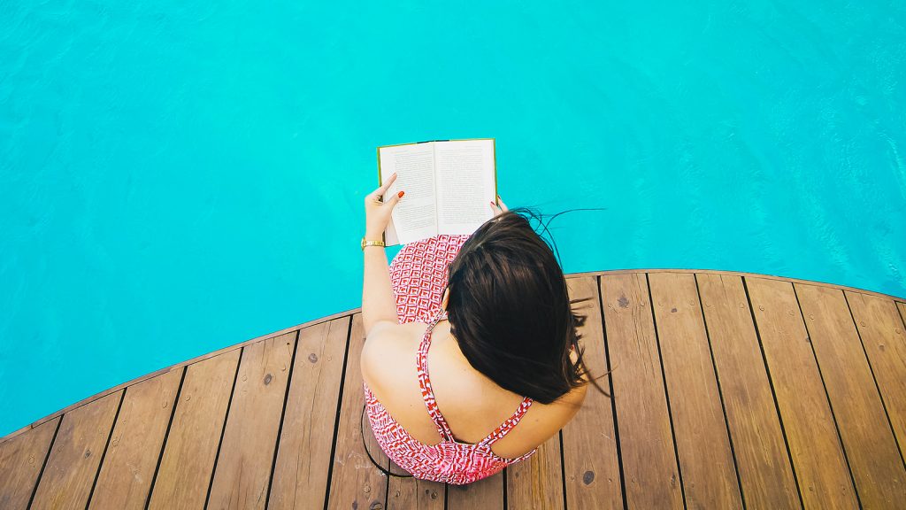 ragazza di spalle che legge un libro