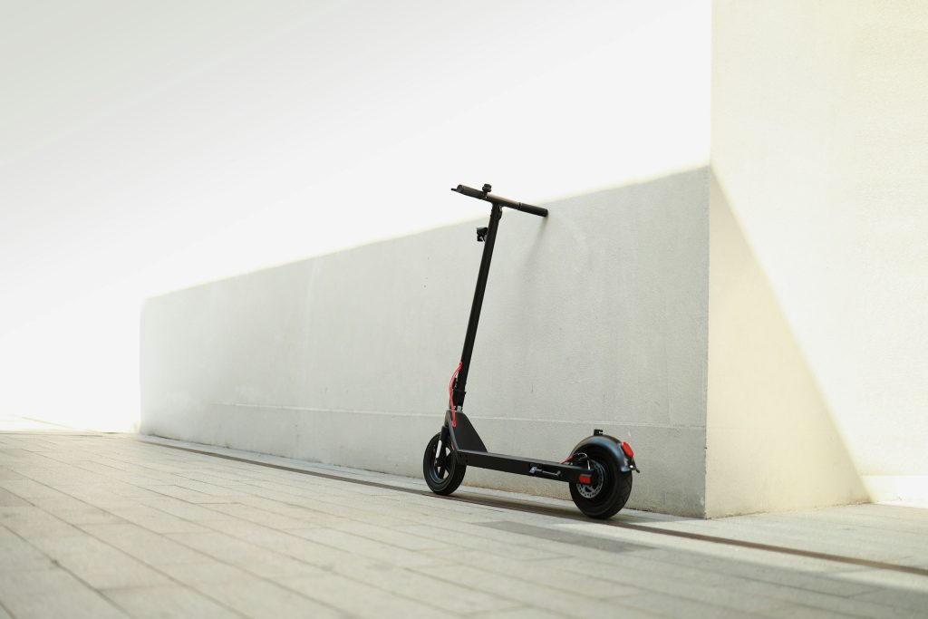 Monopattino elettrico parcheggiato accanto a un muro bianco