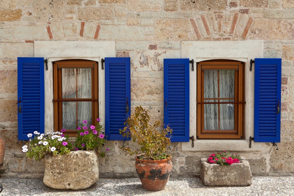 proprietà immobiliare con persiane blu e vasi di fiori