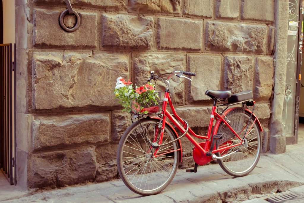 Bicicletta rossa appoggiata a un muro