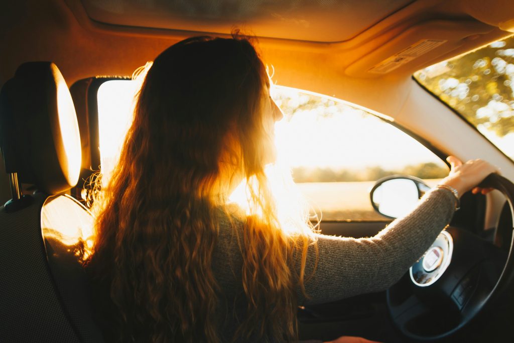 ragazza che guida nella luce del sole