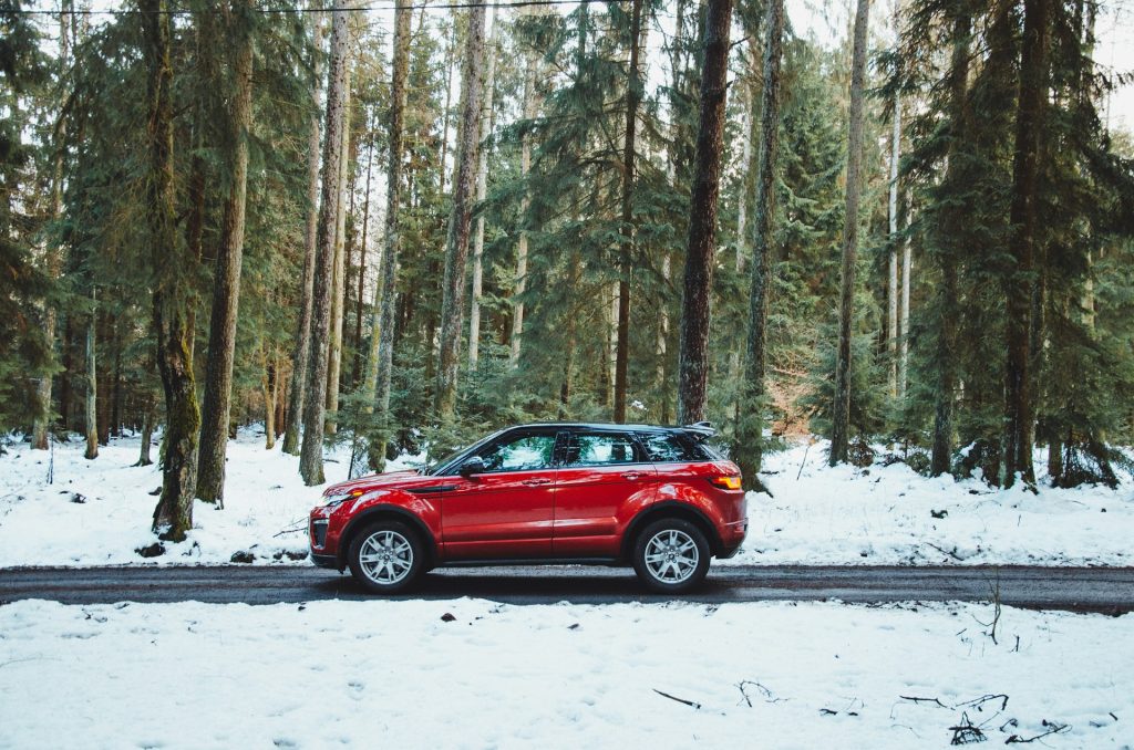 auto rossa su una strada innevata